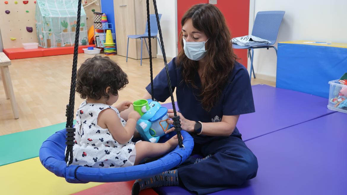 Jessica Romero, terapeuta ocupacional del CAIT San Rafael, en plena terapia con la pequeña Eva